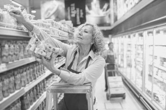 Stock associate putting products on the shelf in a grocery store