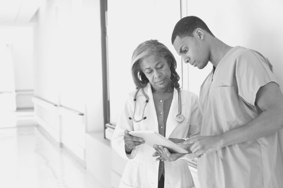 Nurse consultant discussing patient records with a physician.
